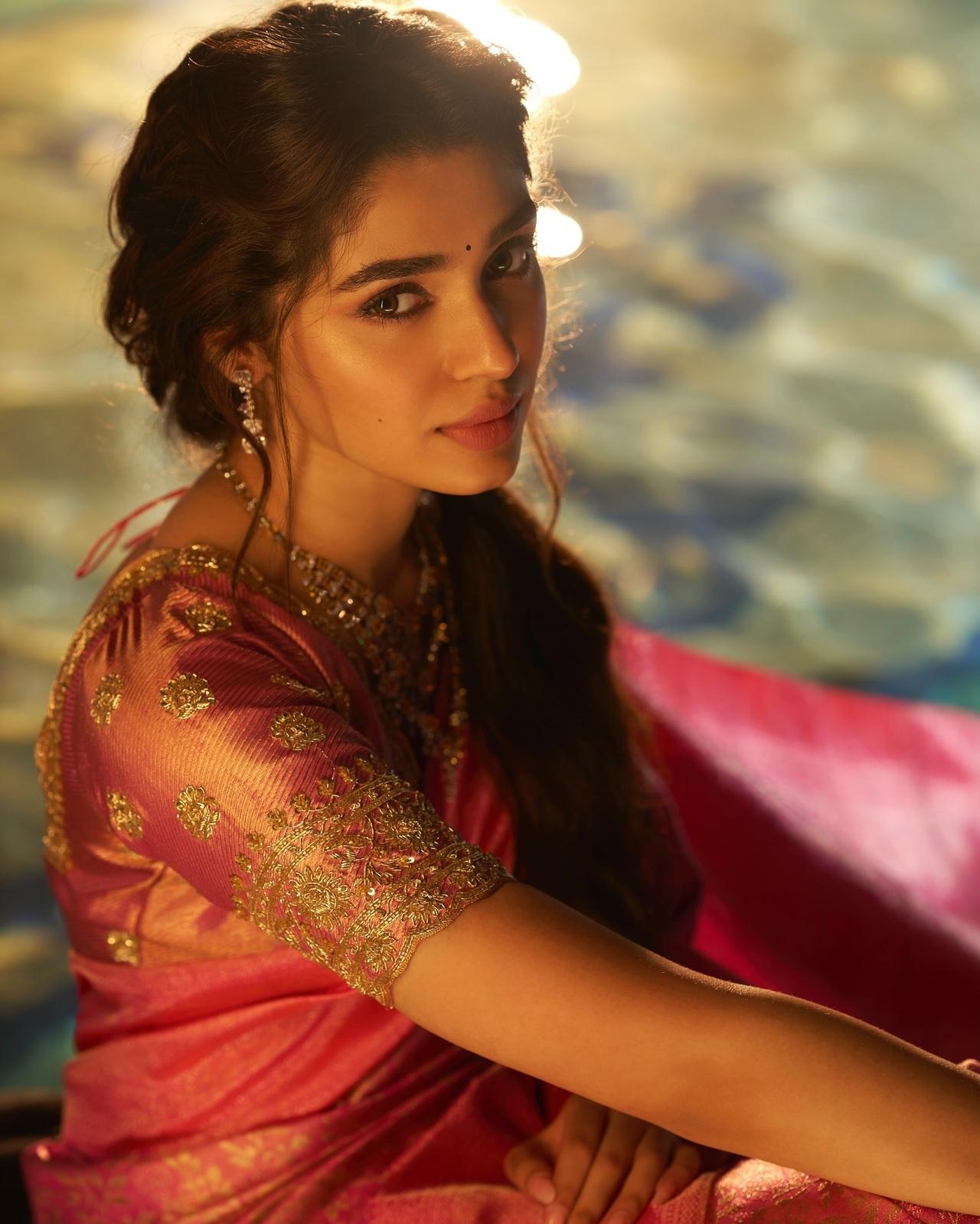 Pretty in pink! Krithi exudes elegance in this pink saree with golden work blouse. She opted for braided hairtyle, minimal jewellery, and dewy makeup that adds charm to the look. 